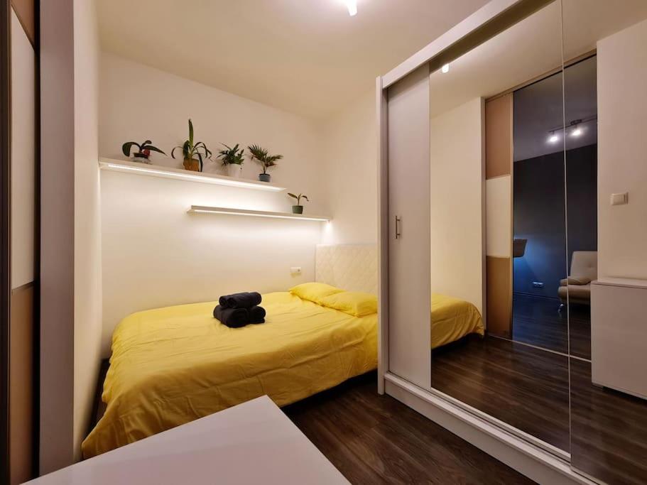 1 dormitorio con cama amarilla y espejo en Nowe Miasto 40 en Rzeszów