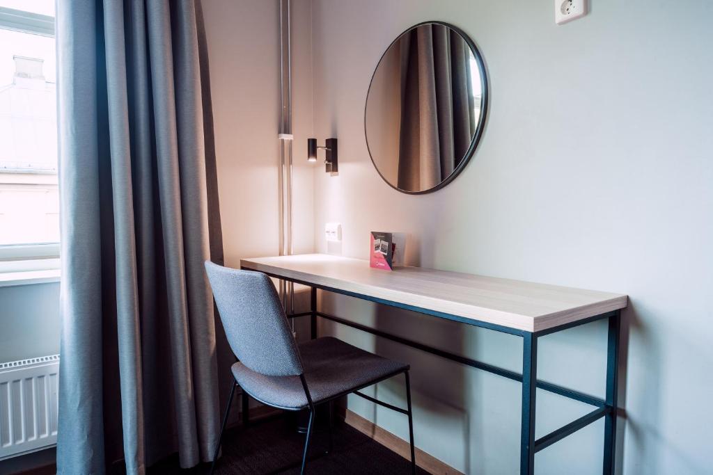 a room with a desk and a mirror and a chair at Citybox Oslo in Oslo