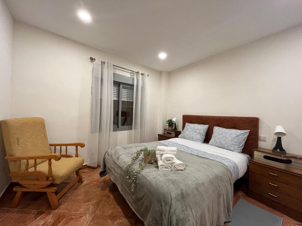 um quarto com uma cama e uma cadeira em Apartamento familiar 3 habitaciones Alcala em Madri