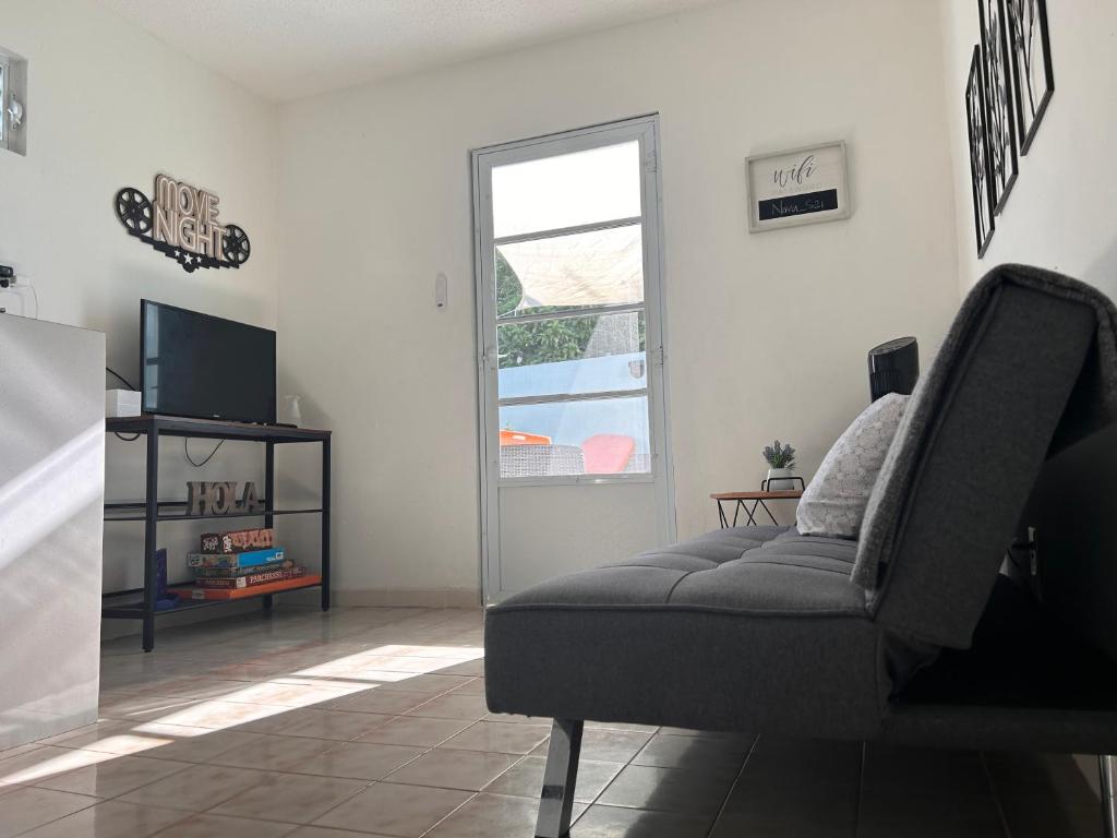 a living room with a couch and a television at Studio21-A Centric Comfort Apartment in Bayamon