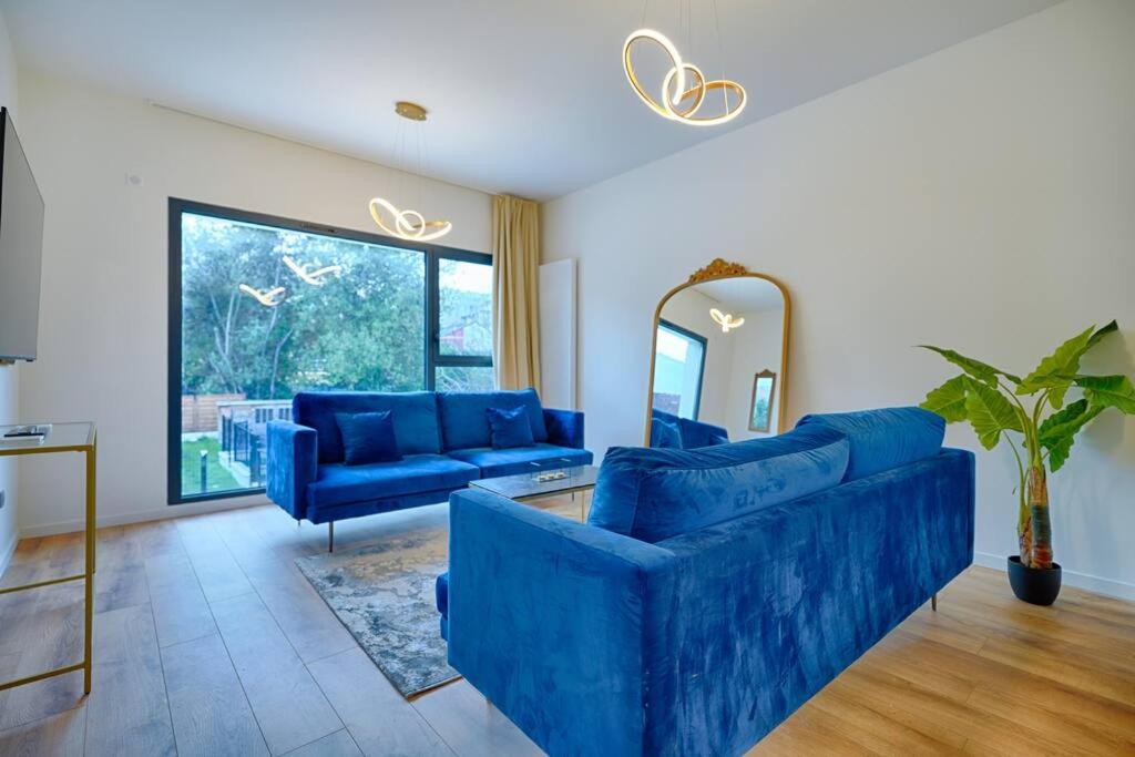 ein Wohnzimmer mit blauen Sofas und einem Spiegel in der Unterkunft Welcome to Paradisio in Alfortville