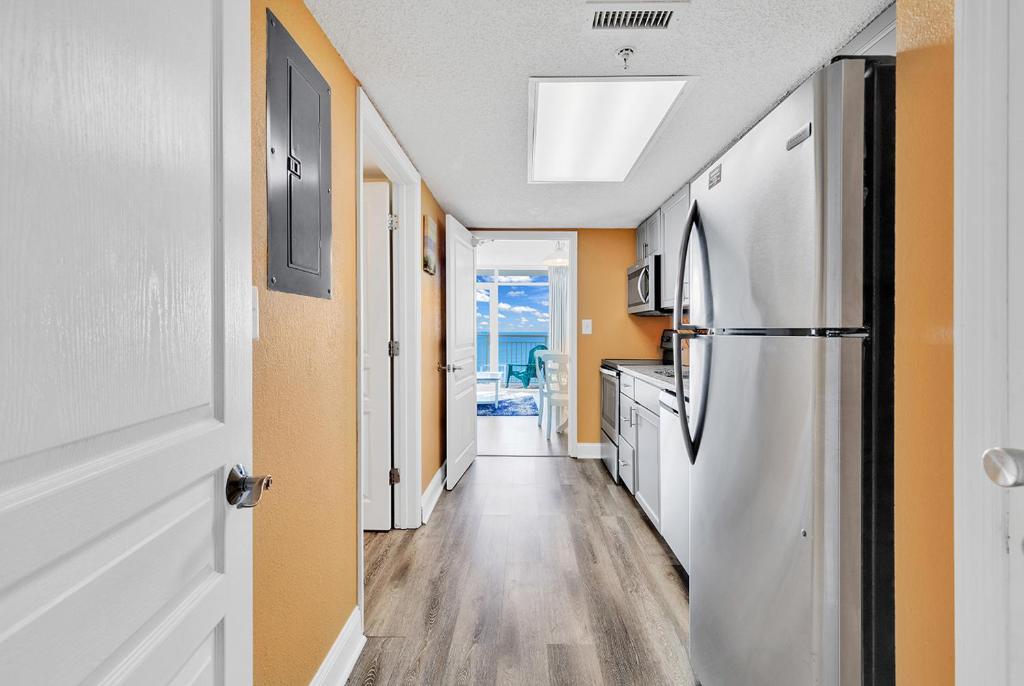 un pasillo con cocina y nevera en una casa en Bay Watch Resort 1203 - Perfect Oceanside Getaway en Myrtle Beach