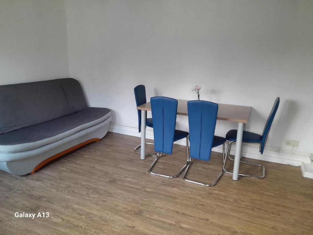 Zimmer mit einem Tisch, Stühlen und einem Sofa in der Unterkunft gemütliche Gäste Suite im Herzen von Neumünster in Neumünster