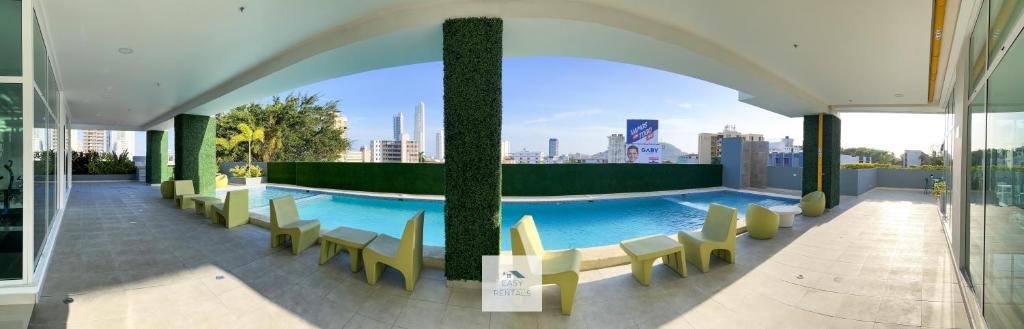 uma piscina com cadeiras e vista para a cidade em H New Apartment, Great Hosts and Location na Cidade do Panamá