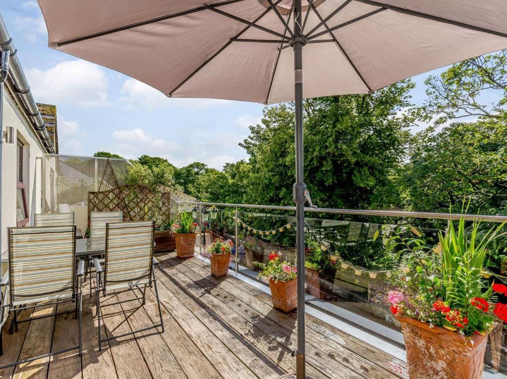 patio con ombrellone e sedie su una terrazza di 2 Bed in Dartmoor 83841 a Ivybridge