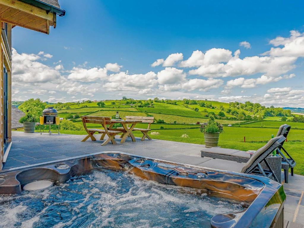 a hot tub on a patio with a picnic table at 2 Bed in Montgomery 83244 in Llandyssil