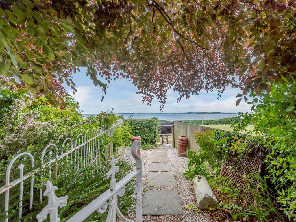 a white fence and a stone path with a gate at 1 Bed in Holywell 83270 in Whitford