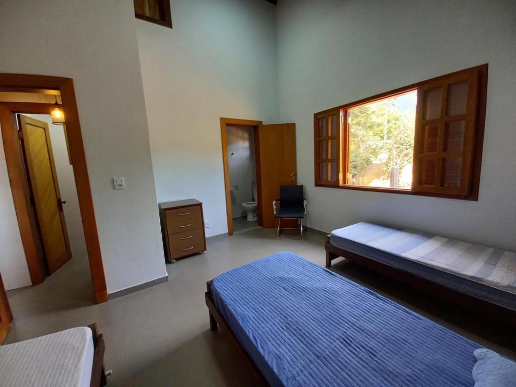 a bedroom with two beds and a window at Reserva Som das Águas in Caparaó Velho