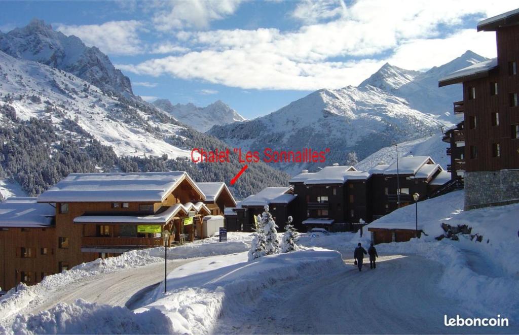 a ski lodge in the mountains with snow on the ground at Appartement Les Sonnailles in Les Allues