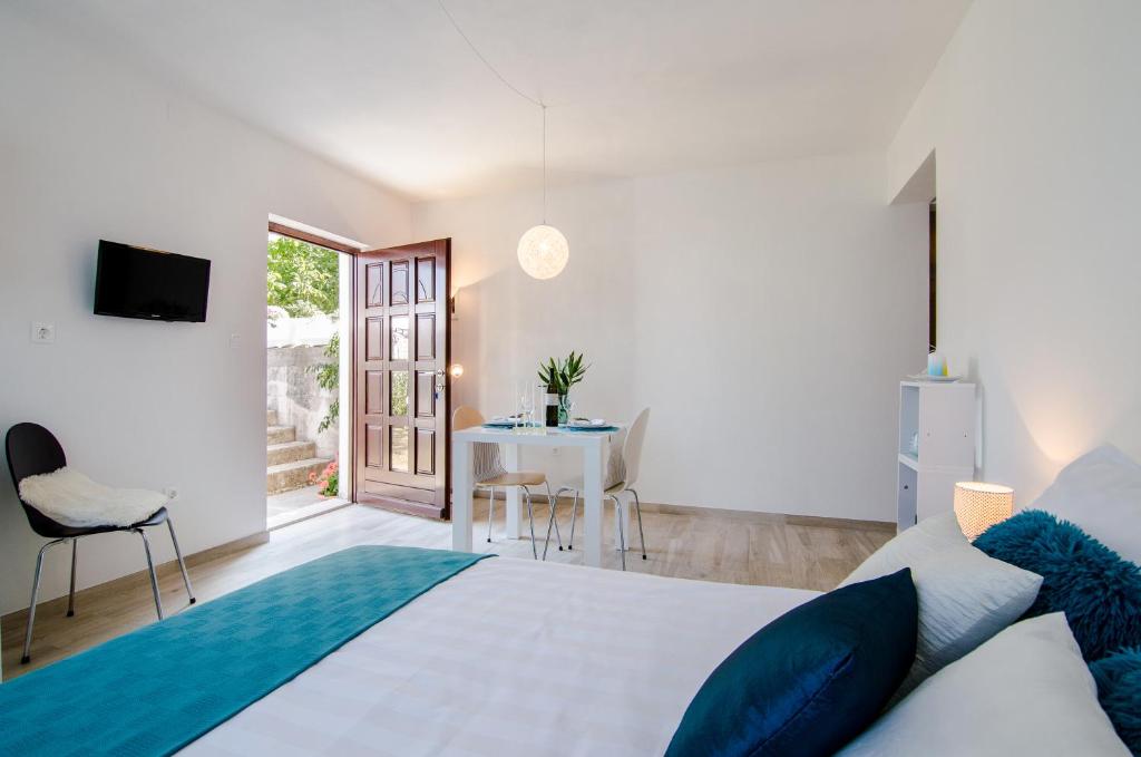 a bedroom with a white bed and a table and chairs at Studio apartment Stella in Labin