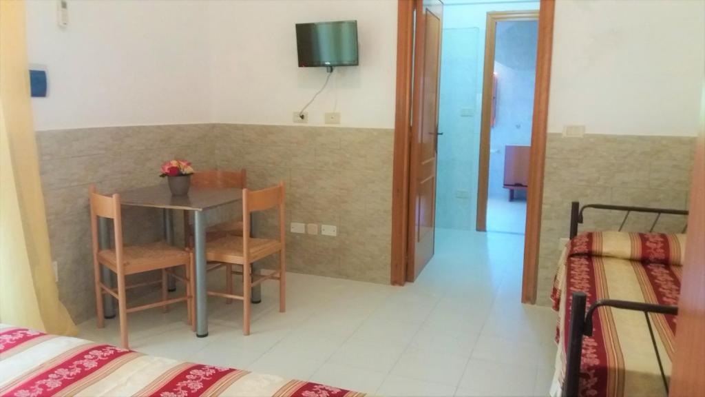 a room with a table and a room with two beds at Hotel Residence Villa Ascoli in Vieste
