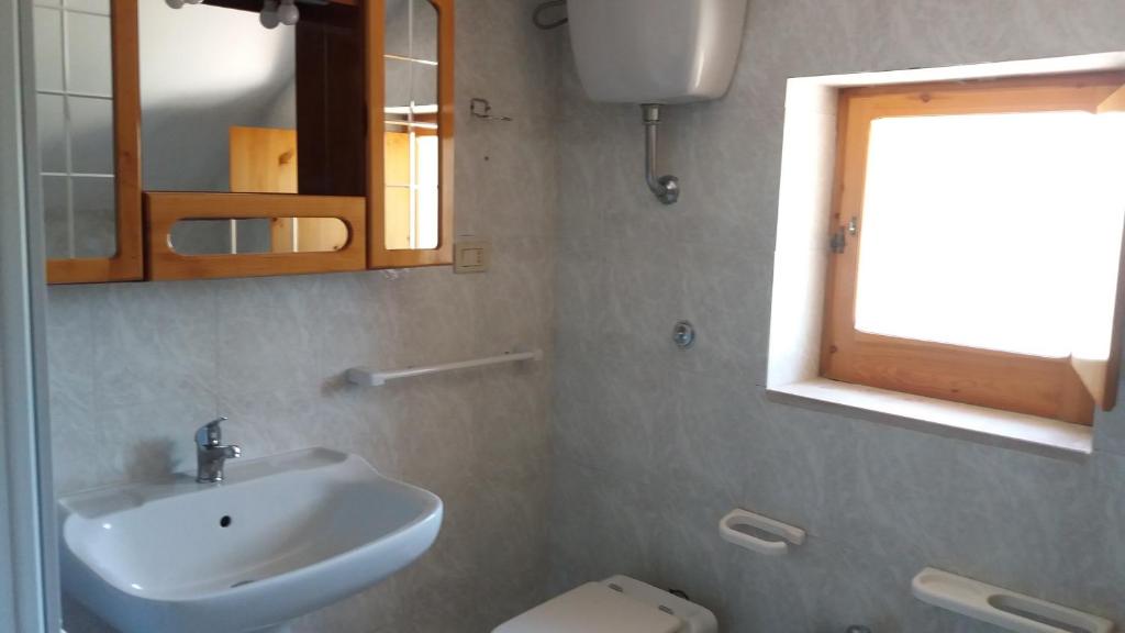 a bathroom with a sink and a toilet and a mirror at Hotel Residence Villa Ascoli in Vieste