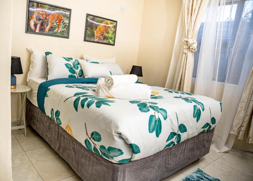 a bedroom with a bed with blue and white sheets at AKEMS MOTEL in Kempton Park