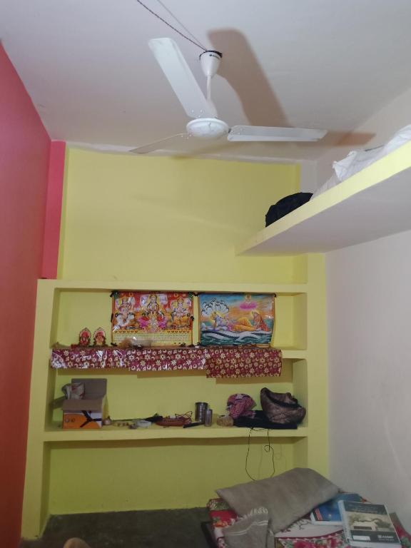Habitación con pared amarilla y techo. en Tourist lodge, en Kānpur