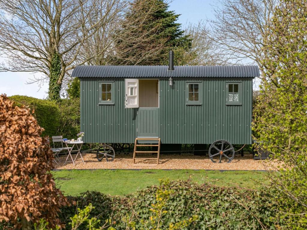 a green tiny house in a garden at 1 Bed in Hayfield 87592 in Mellor