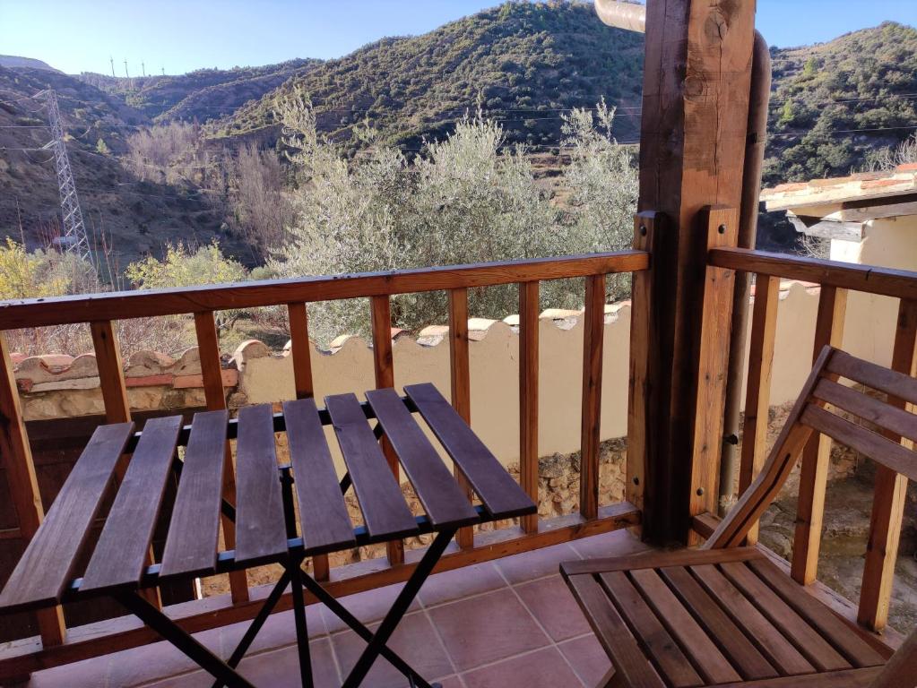 um banco de madeira sentado numa varanda com vista em Maestrazgo Teruel Casa Marco em Luco de Bordón