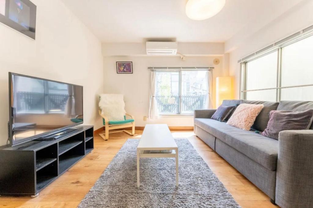 a living room with a couch and a flat screen tv at Apartment in Akihabara Station 3 minutes away, near Tokyo Staフリ in Tokyo