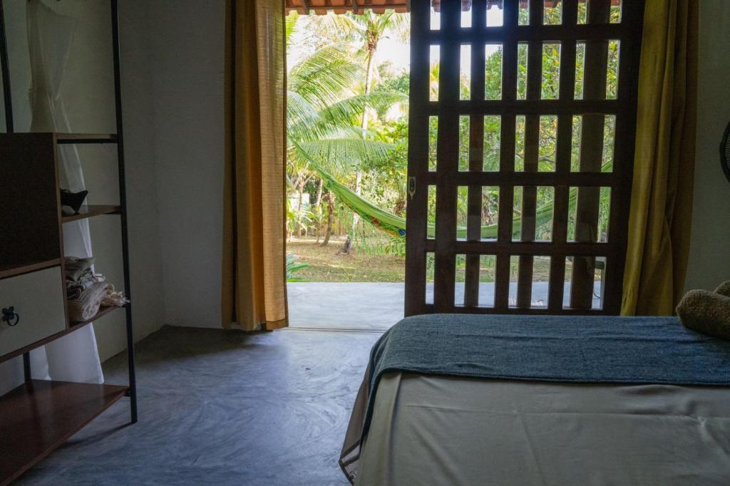 Habitación con cama y puerta corredera de cristal en Chô Chuá, en Cayru