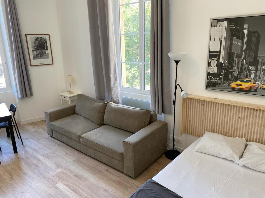 un soggiorno con divano e letto di Studio Grands Boulevards a Parigi