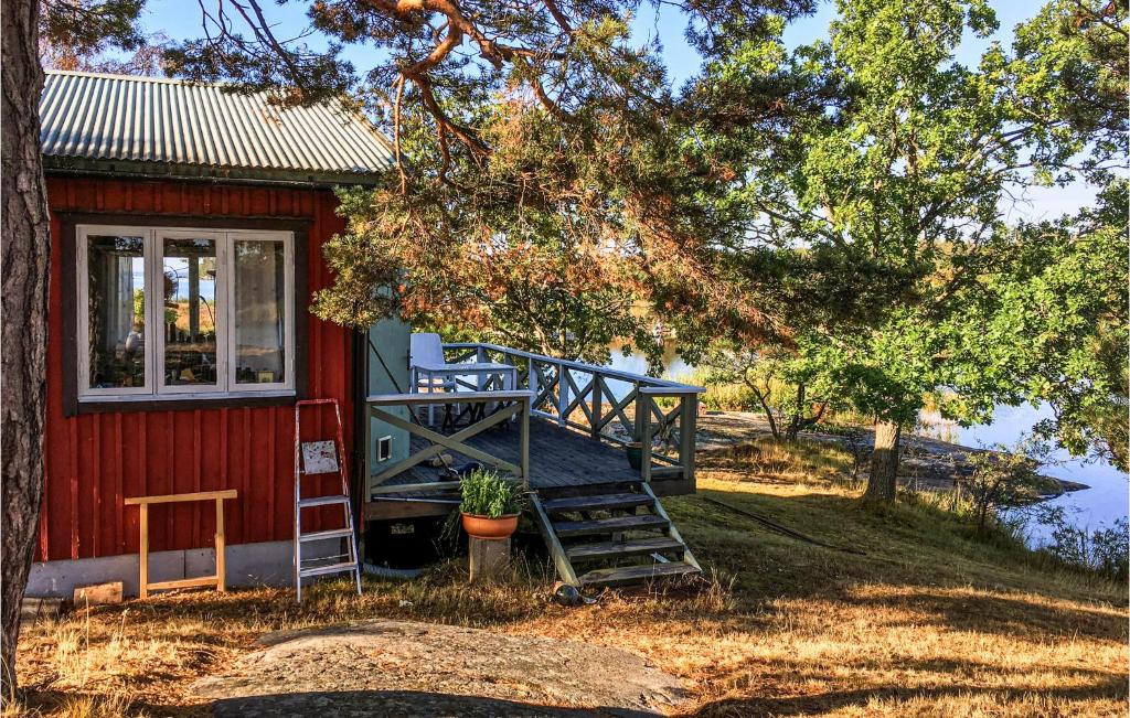een rode hut met een trap naar de deur bij Cozy Home In Oskarshamn With House Sea View in Oskarshamn