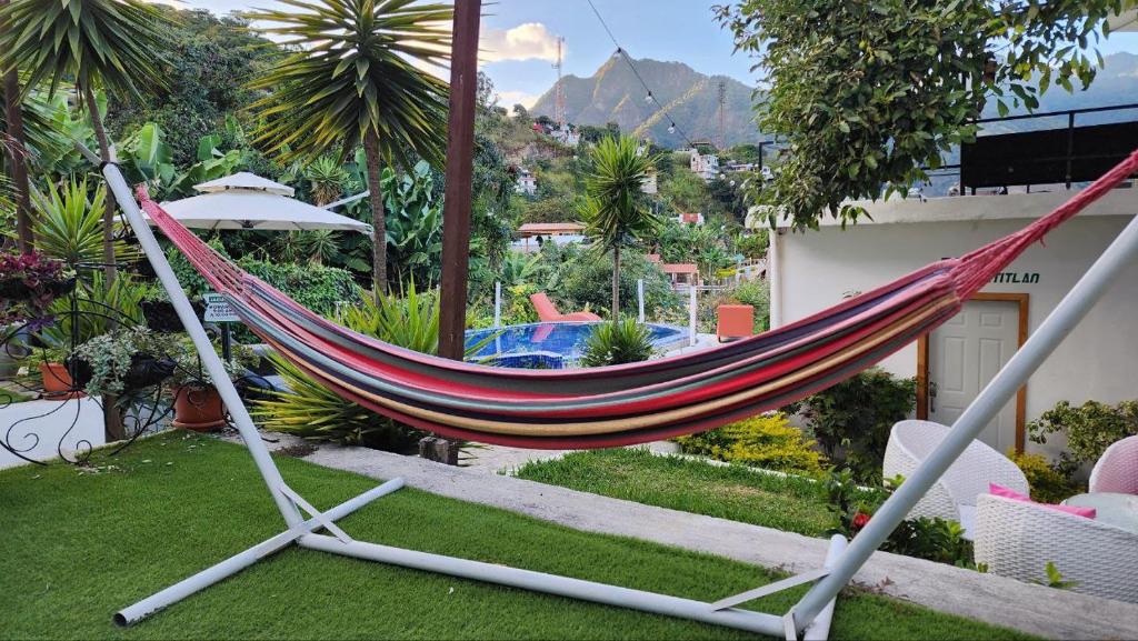a hammock in a garden with a pool at NEW YORK by luxury atitlan in San Pedro La Laguna