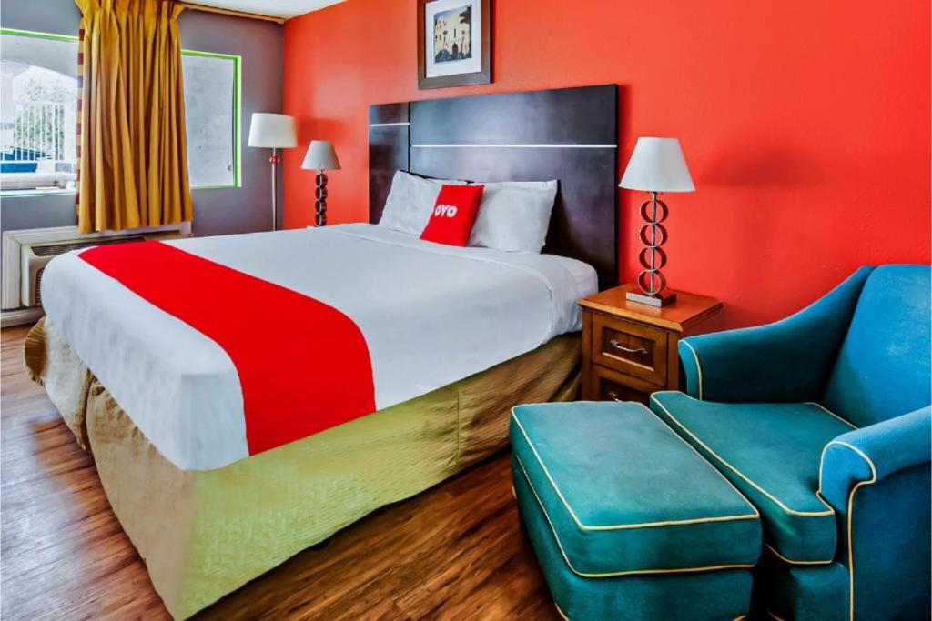 a hotel room with a large bed and a chair at Hotel Europa Ridgecrest in Ridgecrest