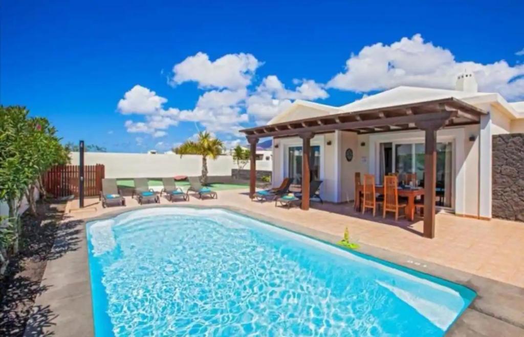 a swimming pool in the backyard of a house at Villa Luna in Yaiza