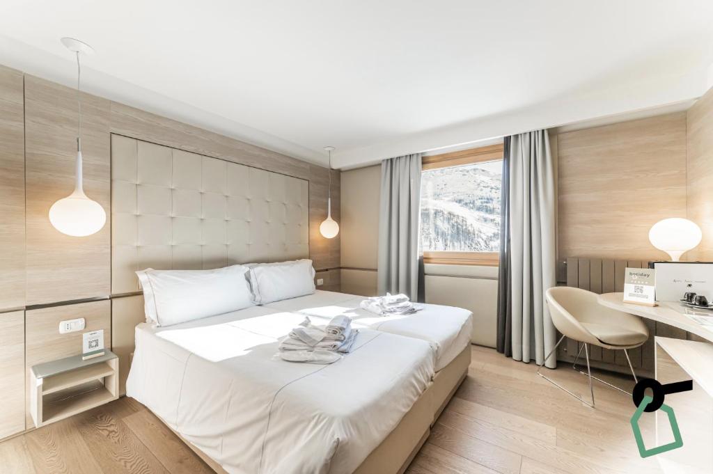 Postel nebo postele na pokoji v ubytování HOTIDAY Room Collection - Cervinia