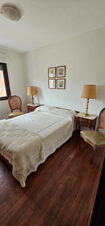 1 dormitorio con 1 cama, 2 sillas y 2 lámparas en 8 Depto de un dormitorio cochera, en Rosario