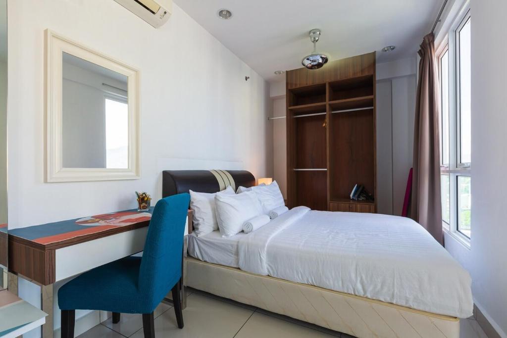 een slaapkamer met een bed, een bureau en een blauwe stoel bij Mansion One by Stay Premium in George Town
