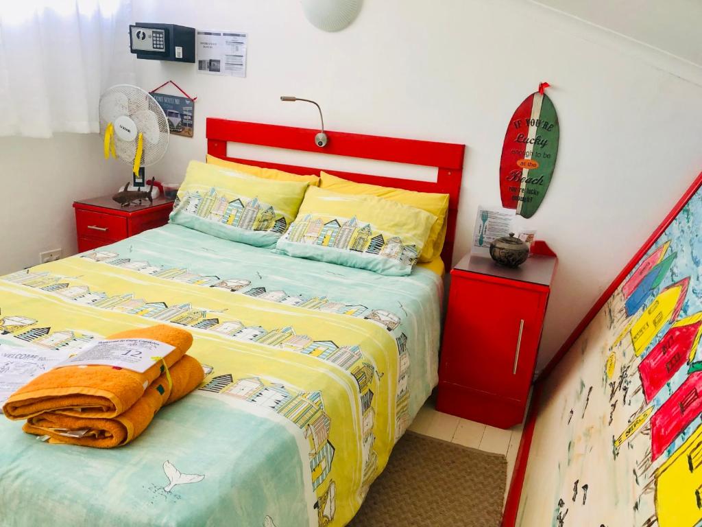 a bedroom with a bed and a surfboard on it at Cape Capsules in Muizenberg