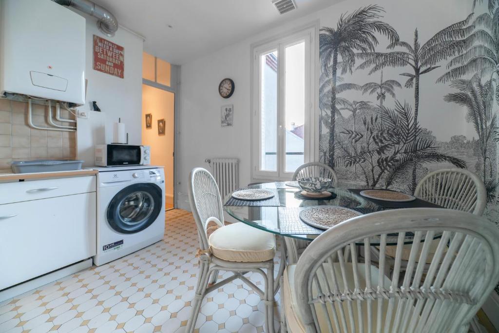 a kitchen with a table and chairs and a washing machine at Le Darcet - Appartement Calme et lumineux in Vichy