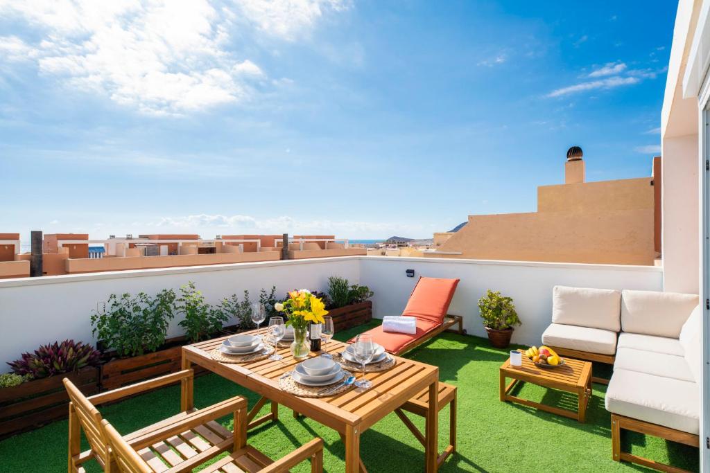 a patio with a table and chairs on a balcony at MEDANO4YOU Casa La Barca Sur in El Médano