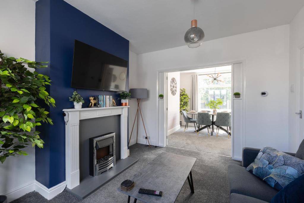 a living room with a blue accent wall and a fireplace at Properties Unique Cleveland House in Stockton-on-Tees