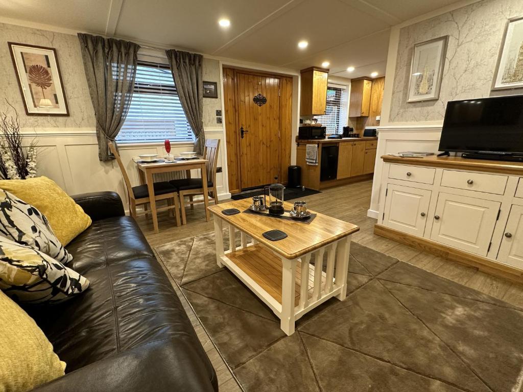 ein Wohnzimmer mit Couch und Tisch in der Unterkunft Picton Cottage Studio - A beautiful newly refurbished annexe with handmade features in Llandowror