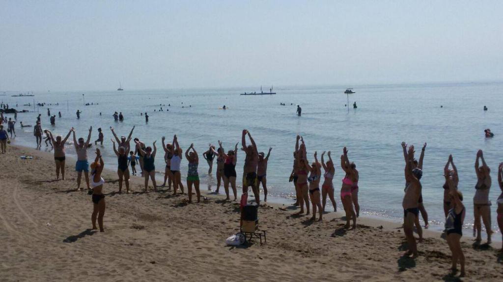a group of people doing yoga on the beach at Hotel Maxim in Caorle