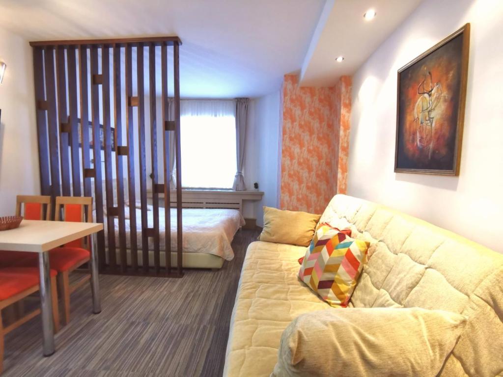 ein Wohnzimmer mit Sofa und ein Schlafzimmer in der Unterkunft Premia Apartments Konaci in Kopaonik