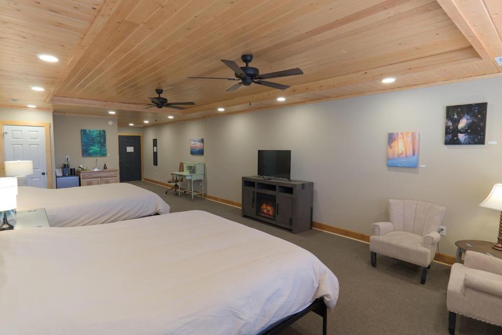 a bedroom with two beds and a flat screen tv at The NuWray Hotel & Carriage House in Burnsville