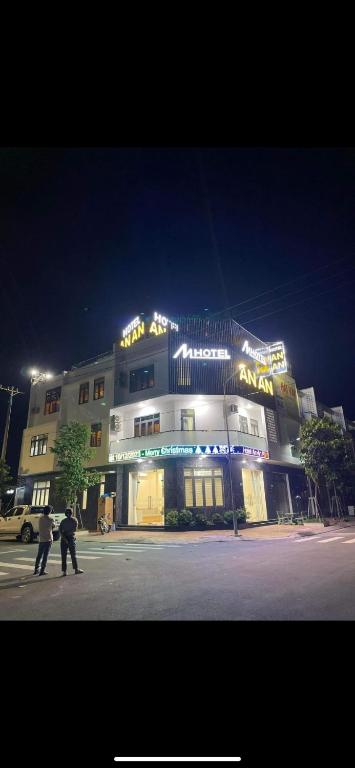 dos personas caminando en frente de un edificio por la noche en Khách sạn An An en Xã Trảng Bôm