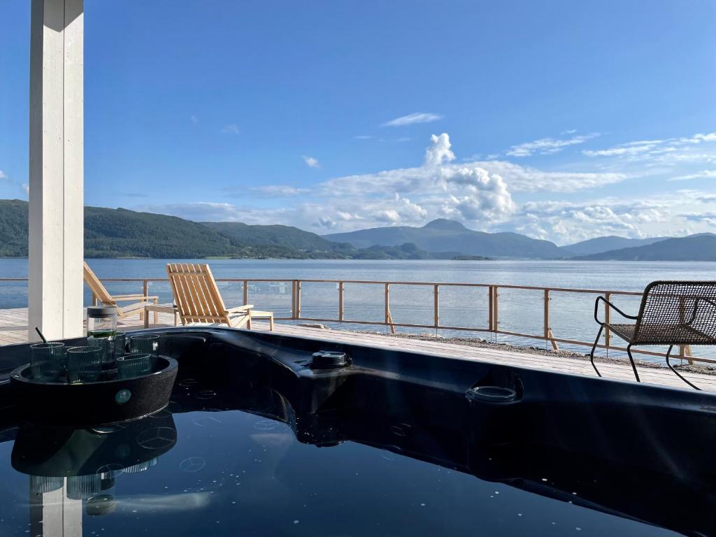 a swimming pool with chairs and a view of the water at Villa Blue Dream in Kristiansund