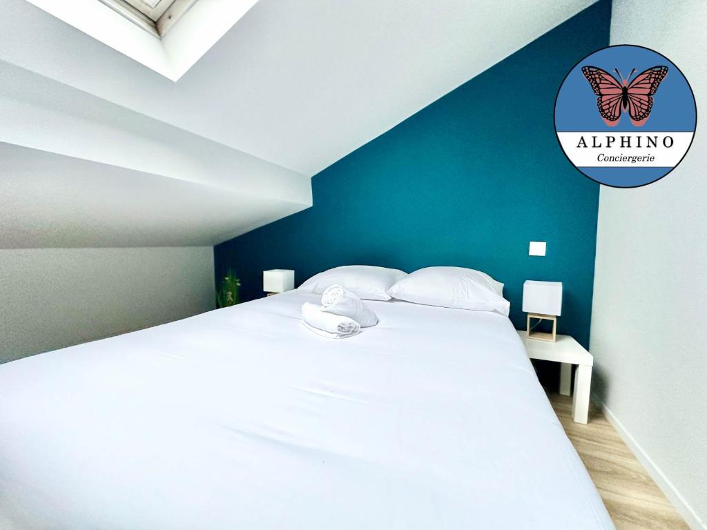 1 dormitorio con cama blanca y pared azul en Le Florissant, intime et raffiné, en Limoges