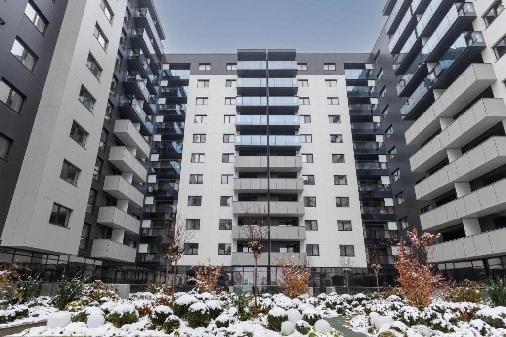 an apartment building with snow in front of it at Cozy Studios in Pipera Business Area - Where Style Meets Functionality in Voluntari