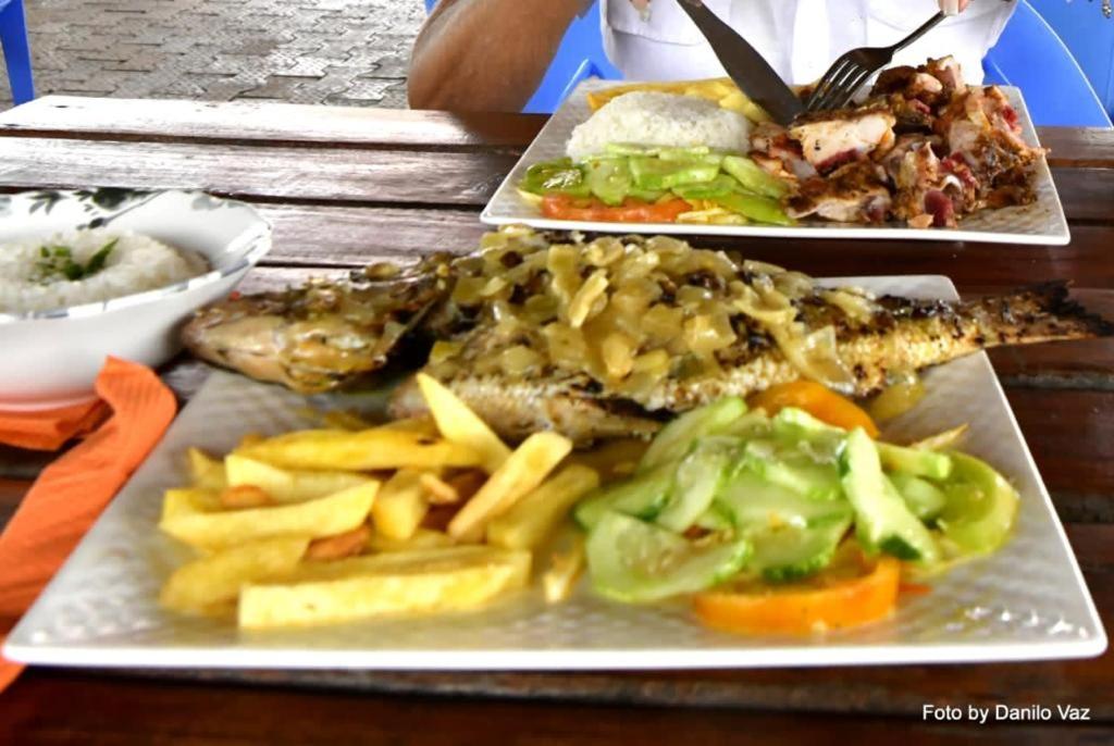 três pratos de comida com peixe e batatas fritas numa mesa em Canafistra Prestige Villa em Plaque
