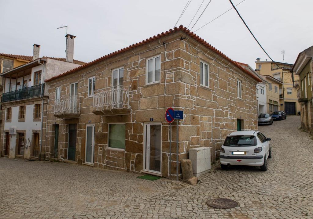 a car parked in front of a brick building at Casa da Praça de Murça in Murça