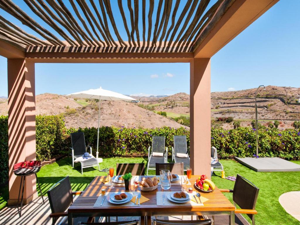 a patio with a table and chairs with a view at Birdie 13 by VillaGranCanaria in La Playa de Arguineguín