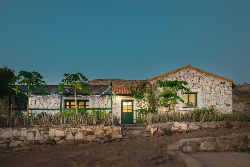 uma casa de pedra com uma porta verde num quintal em Casa Aloé Vera - Private House w/ free Breakfast em Cidade Velha