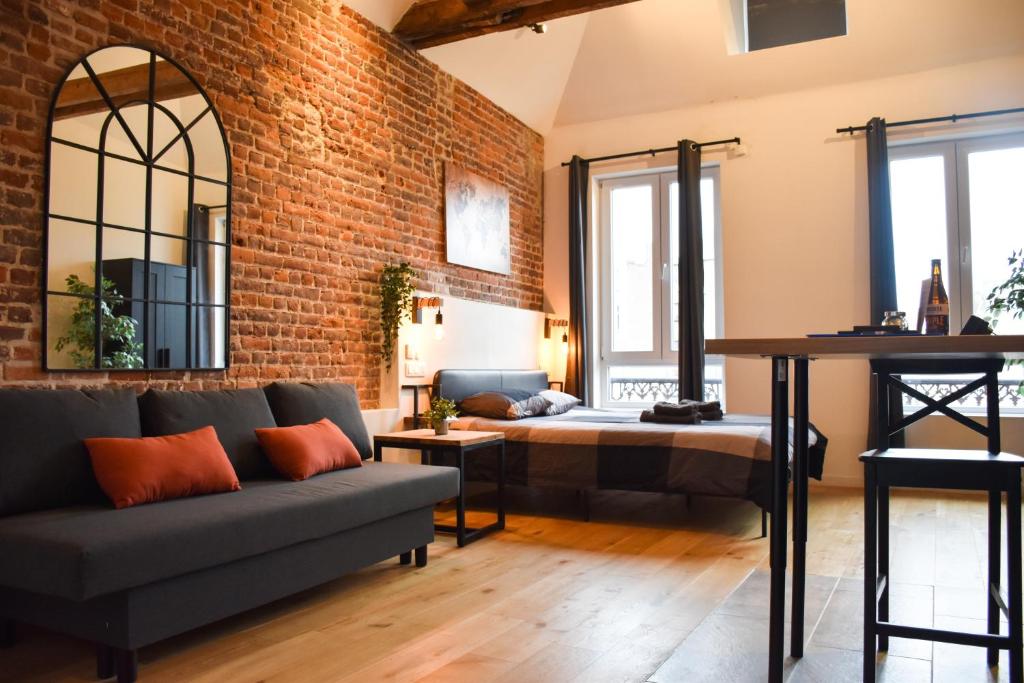 a living room with a couch and a brick wall at Fontainas Apartments in Brussels