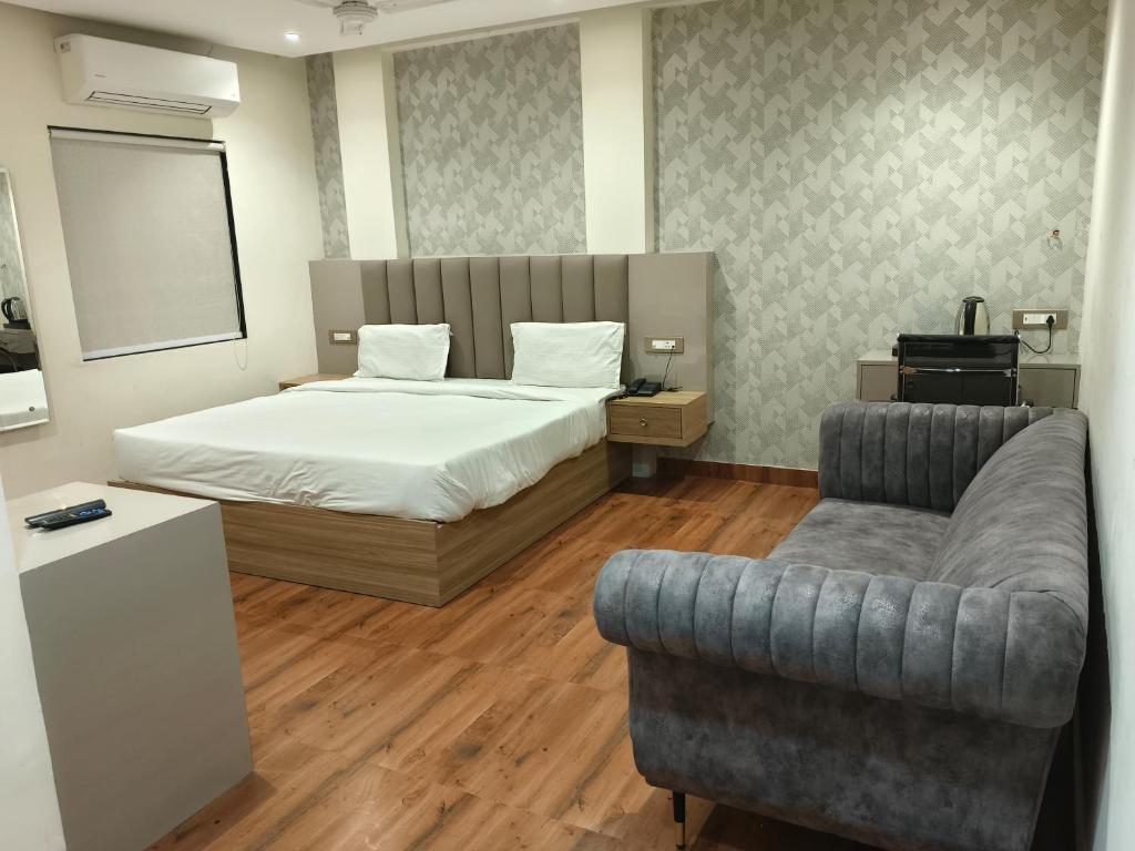 1 dormitorio con 1 cama, 1 sofá y 1 silla en Hotel Sharma Regency, en Lucknow