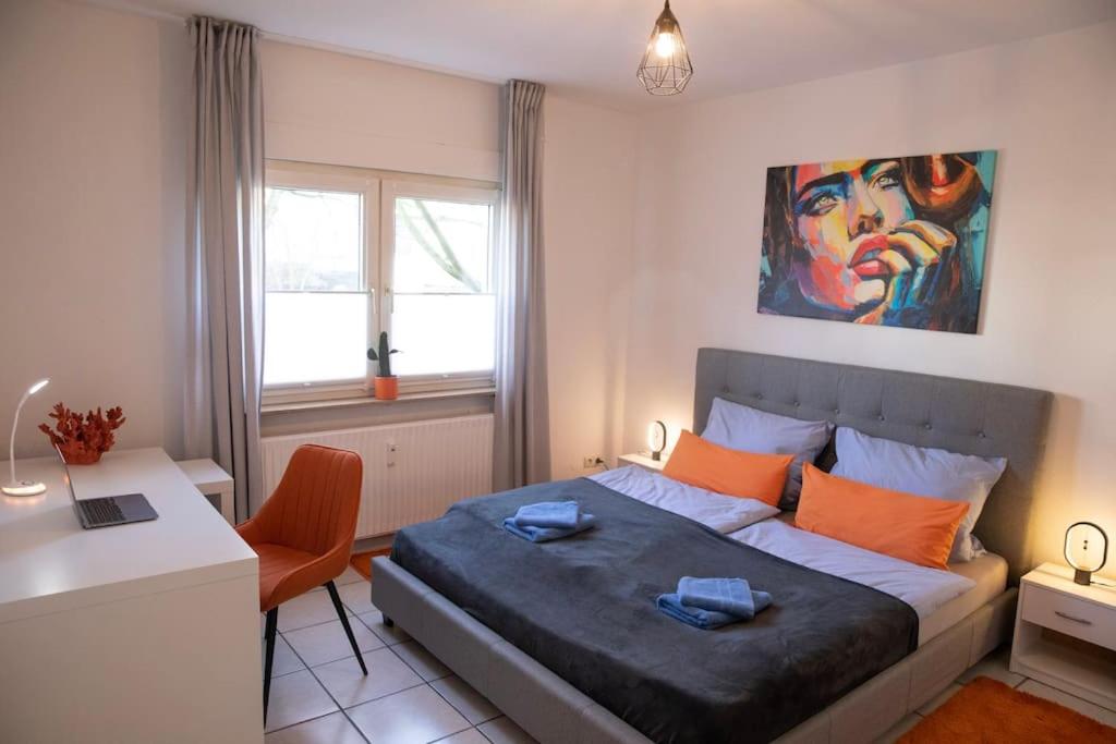 a bedroom with a bed and a desk and a painting at Modern und stilvoll zwischen Innenstadt und Rü in Essen