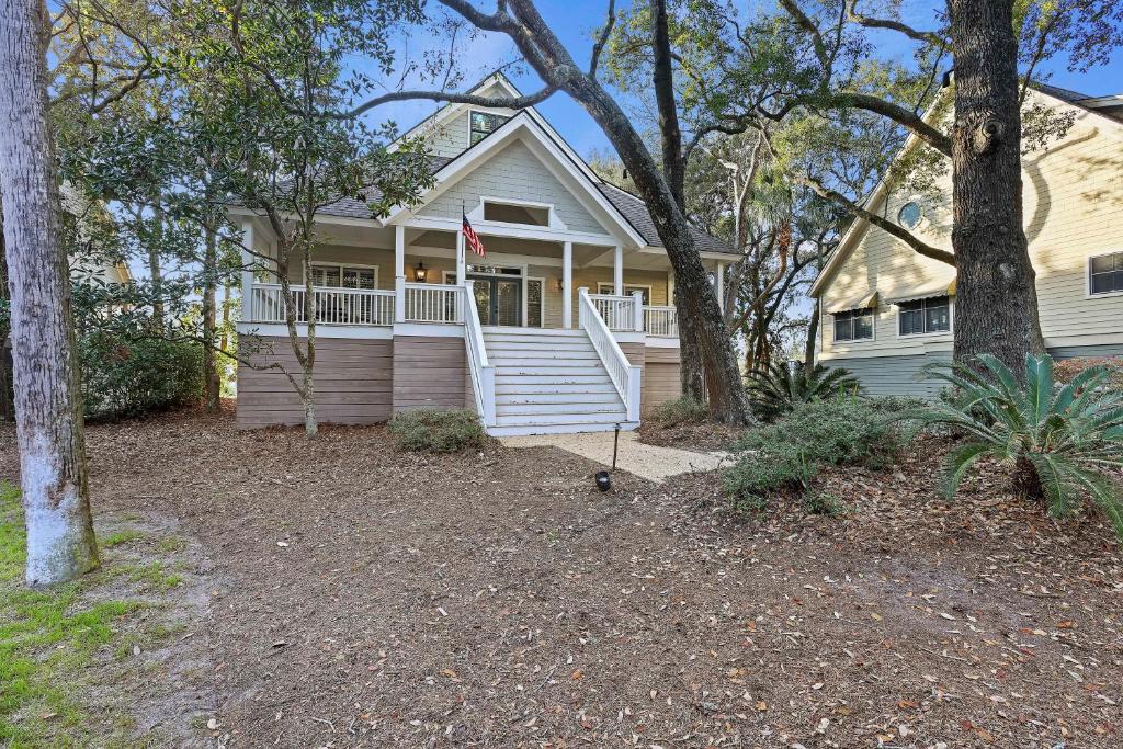 a white house with a porch and a flag at 5 Silver Moss in Kiawah Island